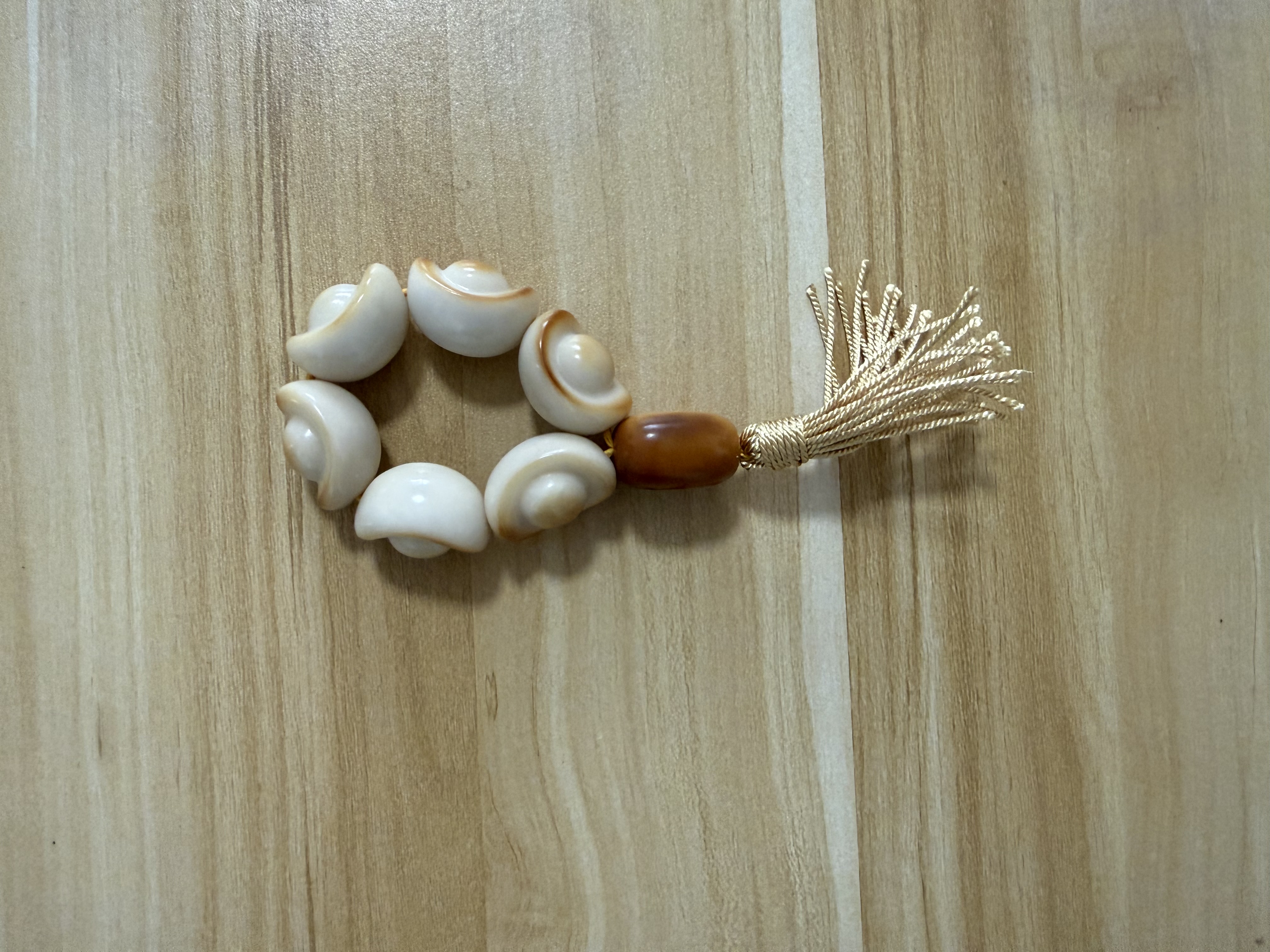 Looped shell beaded bracelet with cream tassel