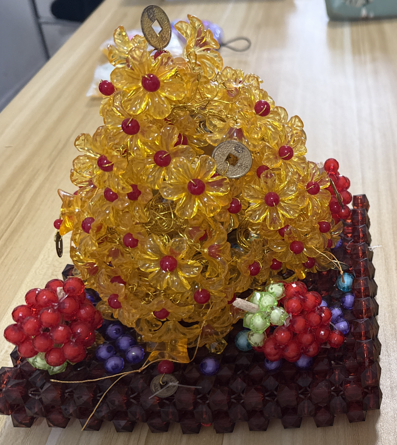 Yellow beaded flower sculpture with red bead centers
