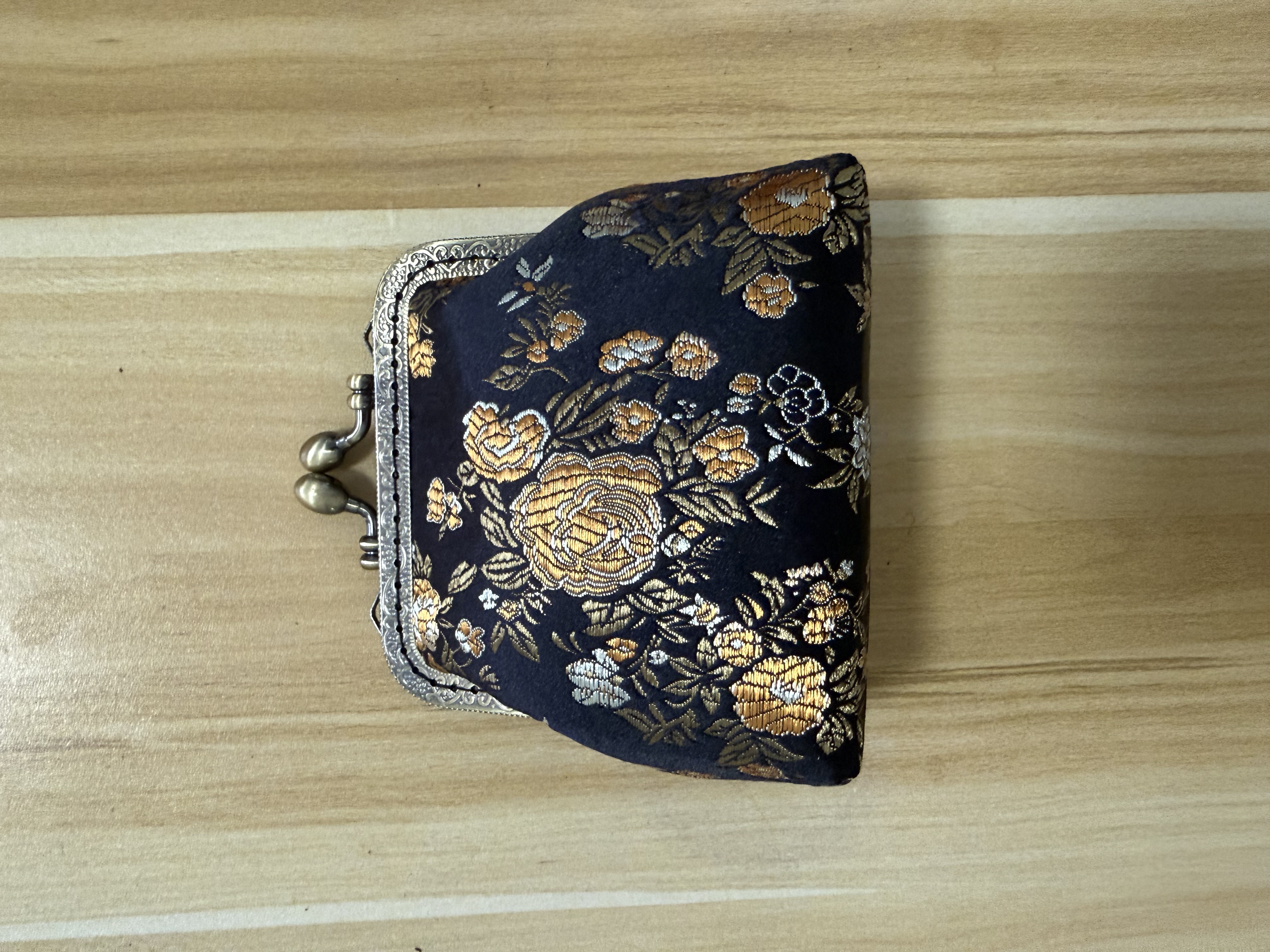 Black frame clutch purse with gold floral pattern
