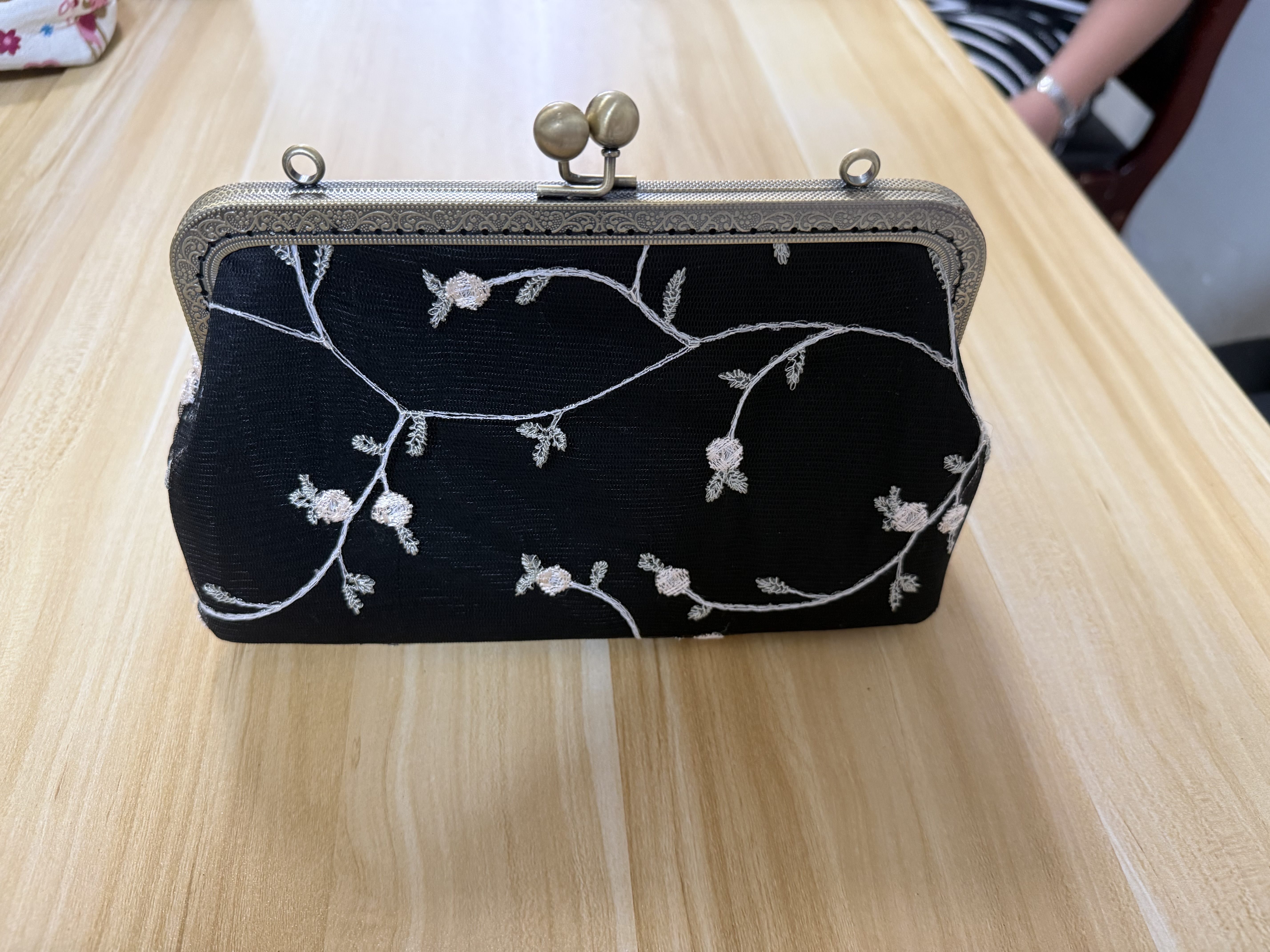 Black frame clutch purse with silver floral embroidery